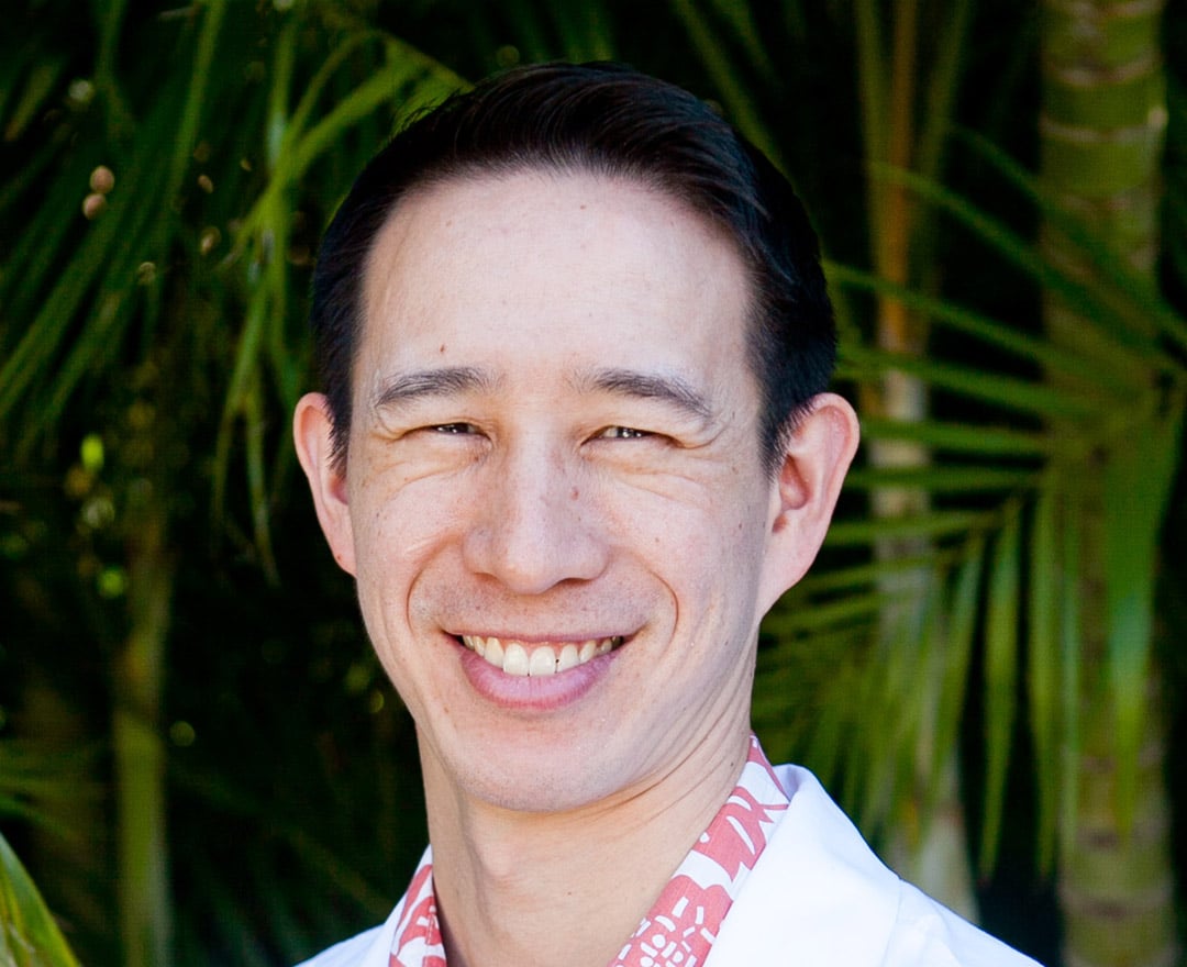 Jeffrey Wong cataract surgeon smiling in tropical background of Hawaii