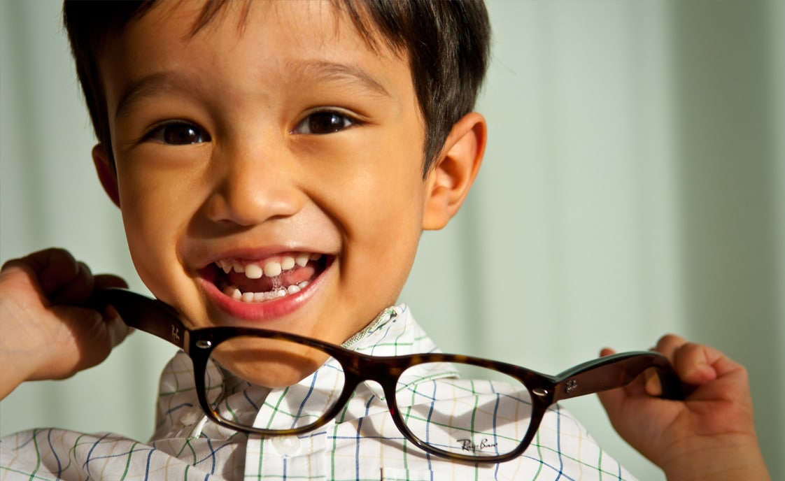 Young boy holding glasses